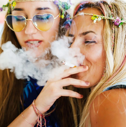 Two women smiling and smoking together